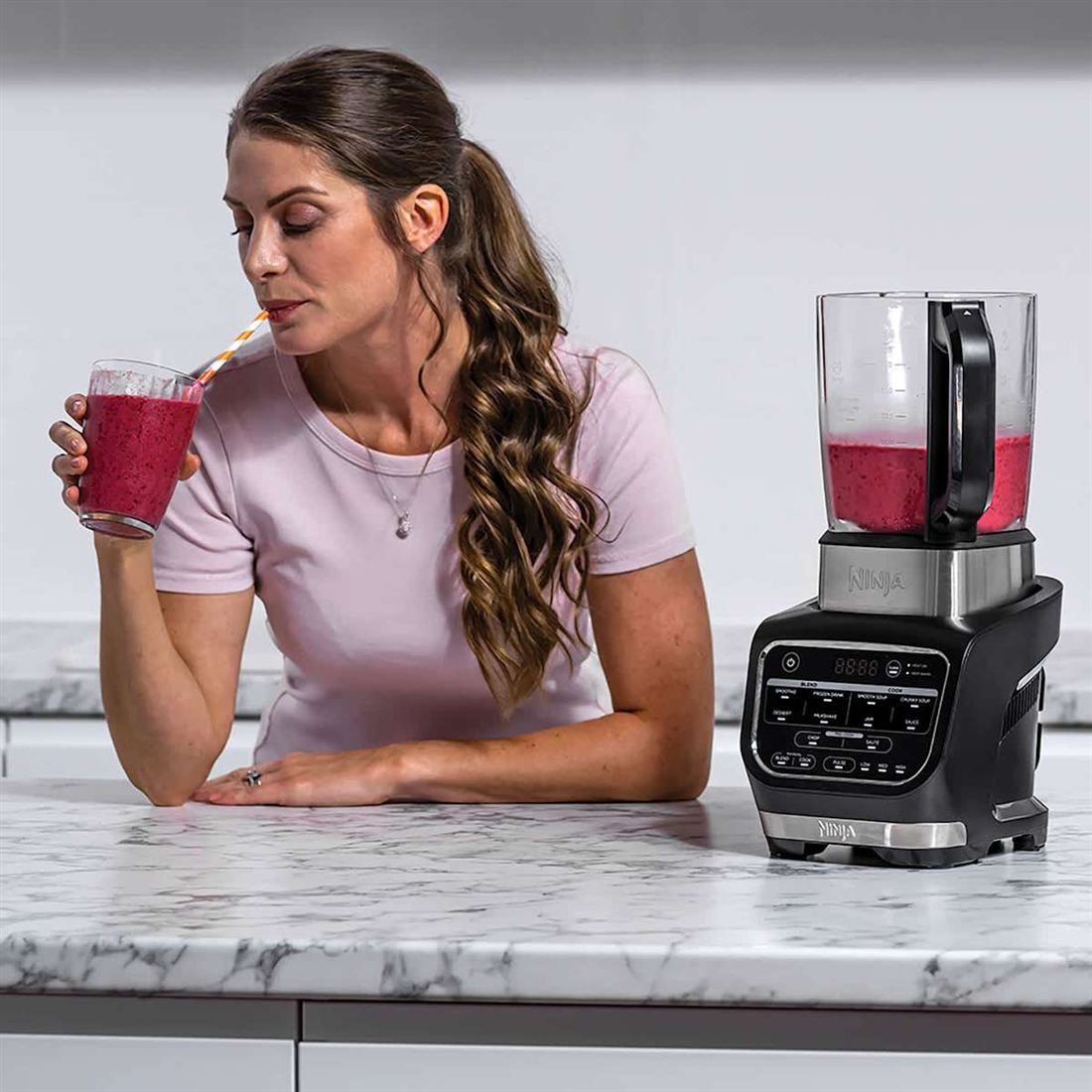 Berry smoothie ready to drink next to the Ninja Foodi Blender and Soup Maker
